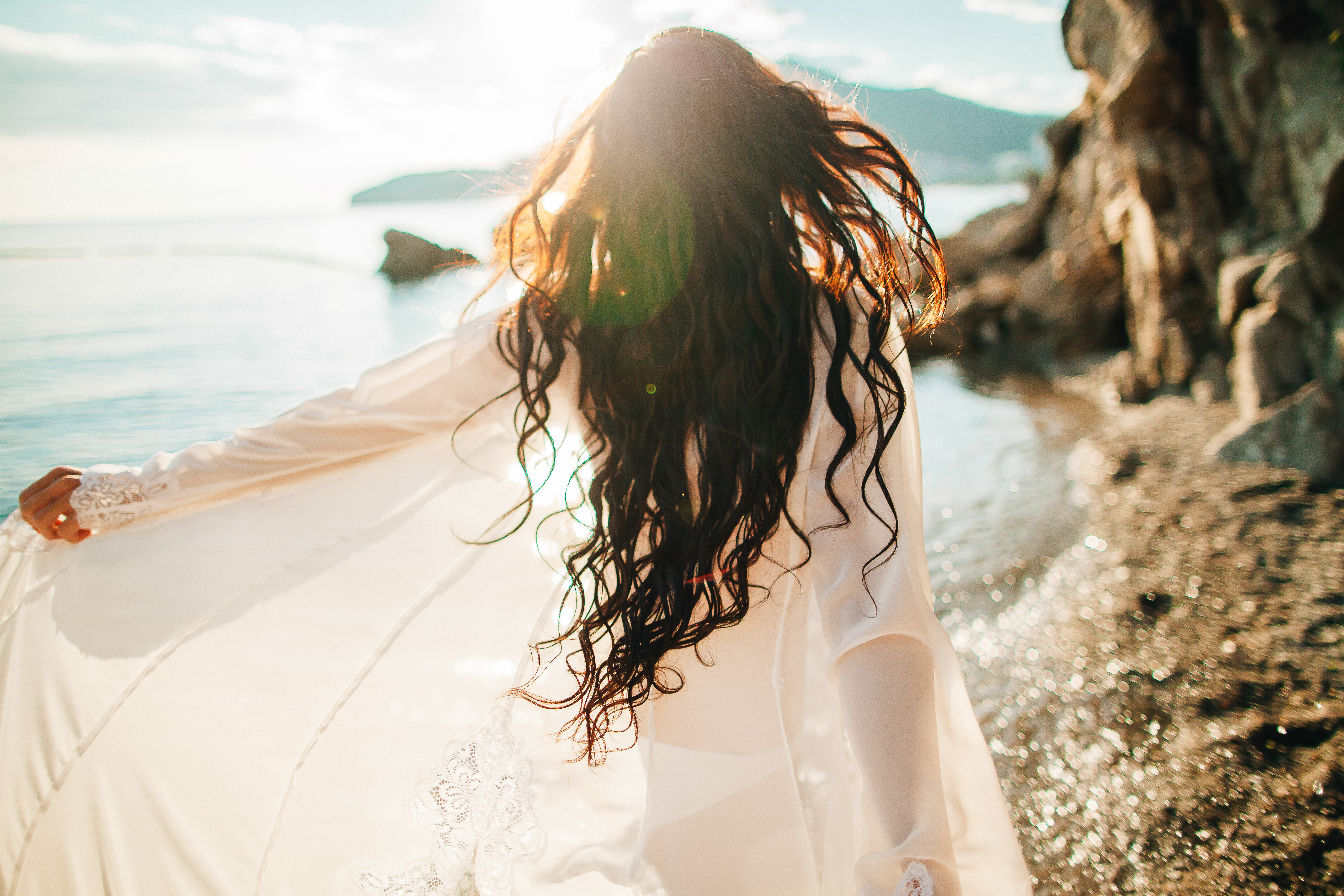 Кудри ветер. Девушка с длинными волосами на море. Девушка на берегу моря. Фотосессия на море. Развивающиеся волосы.
